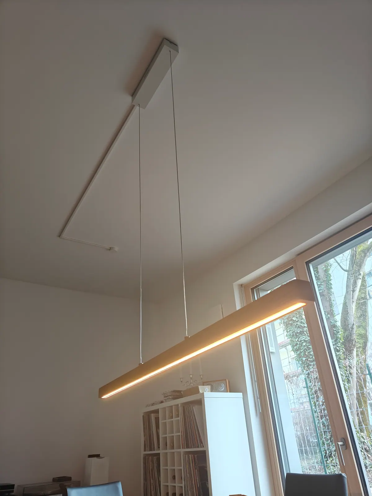 Lineare Holz-Pendelleuchte mit LED-Unterseite an der Decke