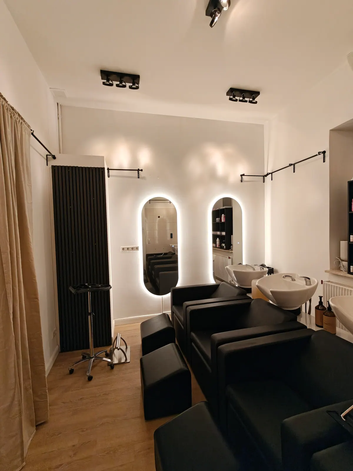 Friseursalon mit ovalen hintergrundbeleuchteten Wandspiegeln