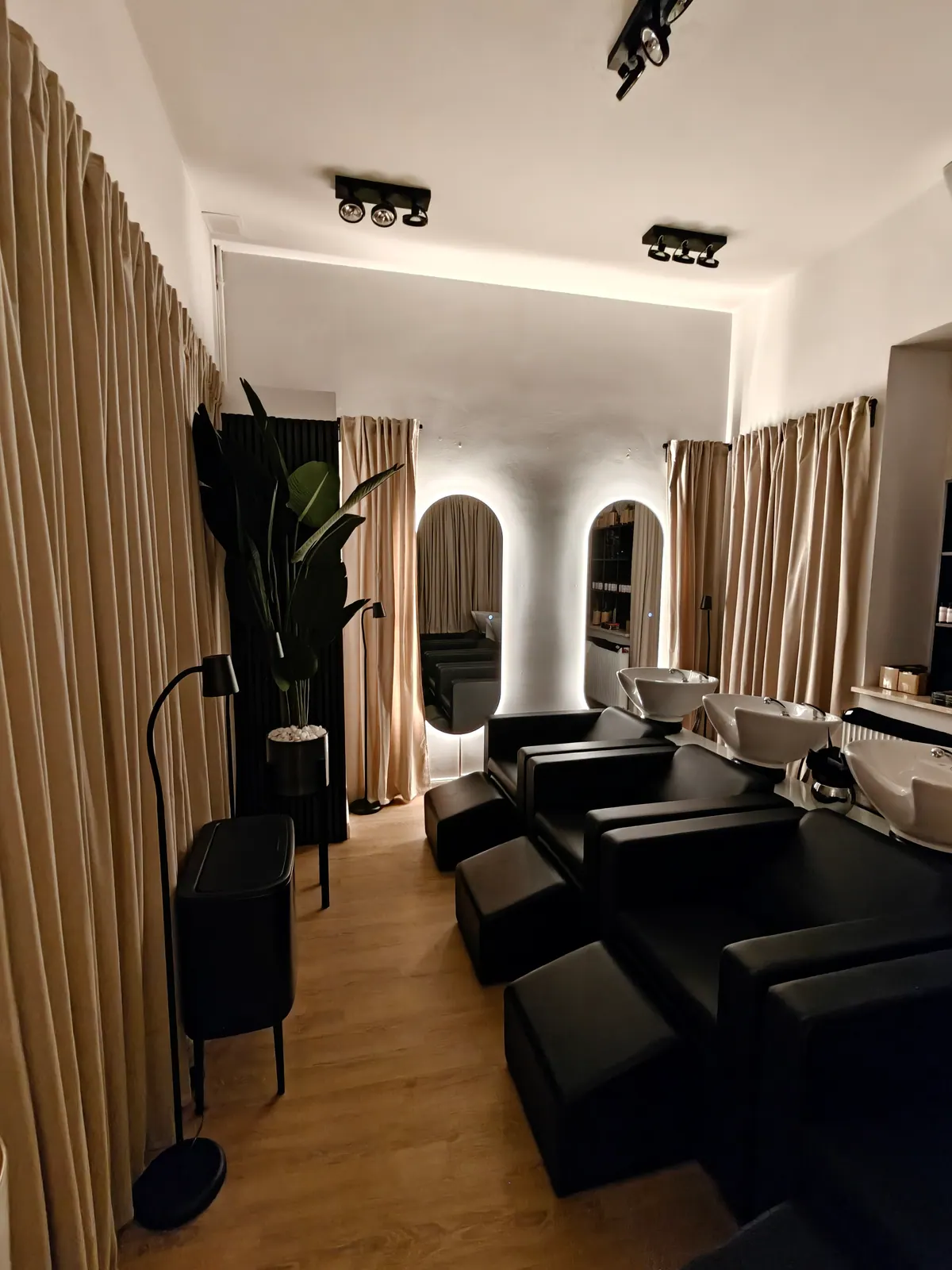 Friseursalon mit Waschstationen, Deckenspots und beleuchteten Spiegeln